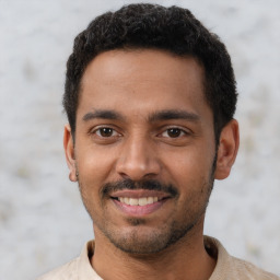 Joyful latino young-adult male with short  black hair and brown eyes