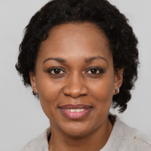 Joyful black adult female with short  brown hair and brown eyes
