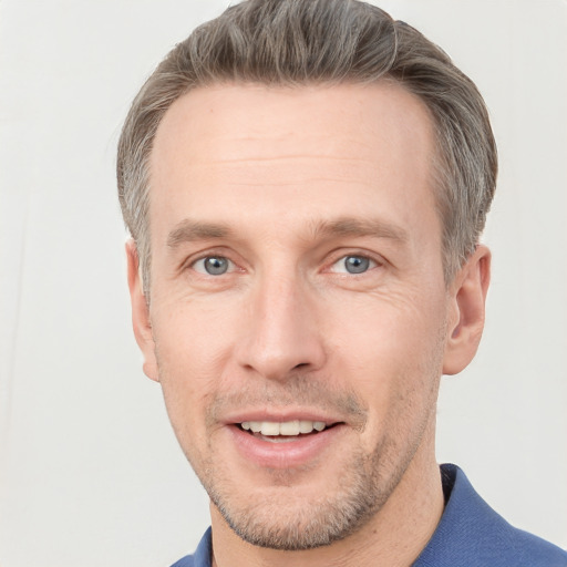 Joyful white adult male with short  brown hair and grey eyes