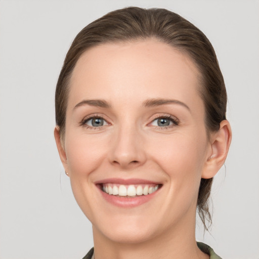 Joyful white young-adult female with medium  brown hair and grey eyes