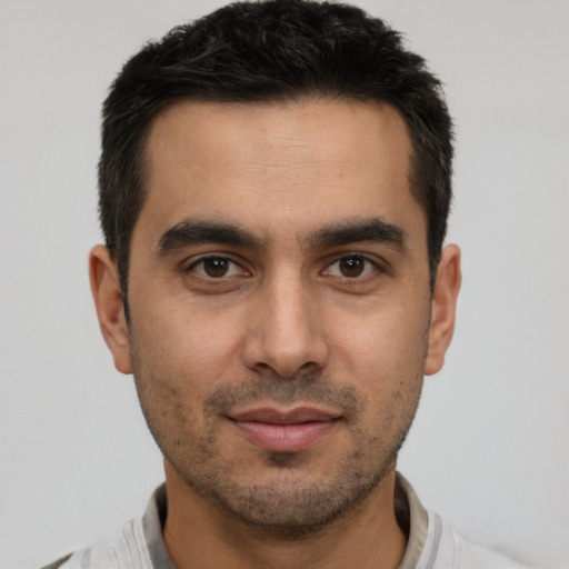 Joyful latino young-adult male with short  brown hair and brown eyes