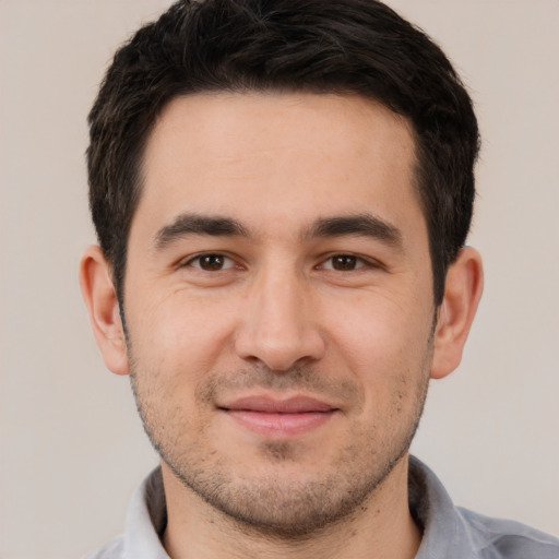 Joyful white young-adult male with short  black hair and brown eyes