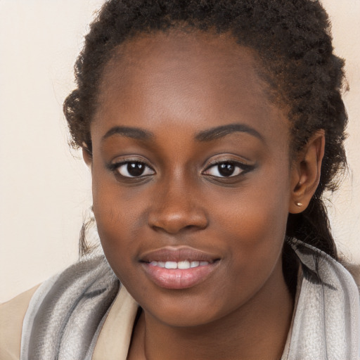 Joyful black young-adult female with long  brown hair and brown eyes