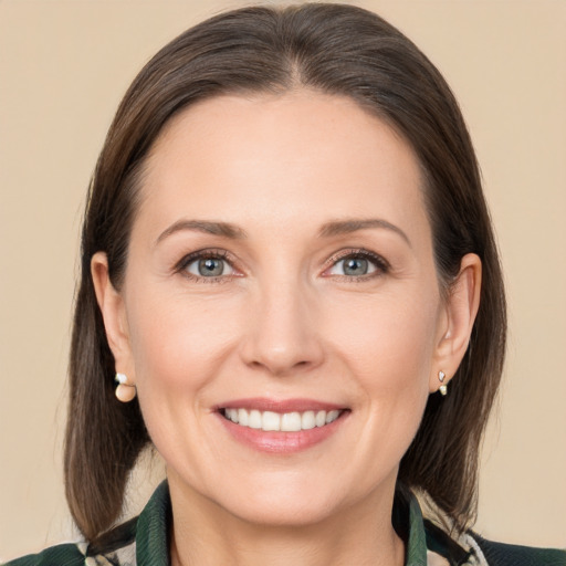 Joyful white adult female with medium  brown hair and grey eyes