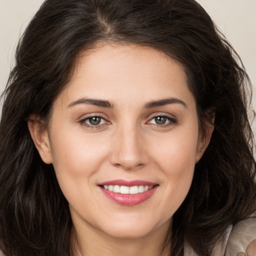 Joyful white young-adult female with long  brown hair and brown eyes