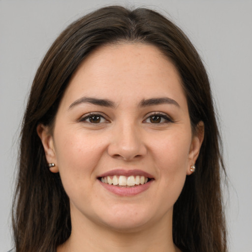 Joyful white young-adult female with long  brown hair and brown eyes