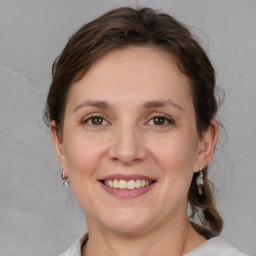 Joyful white adult female with medium  brown hair and grey eyes