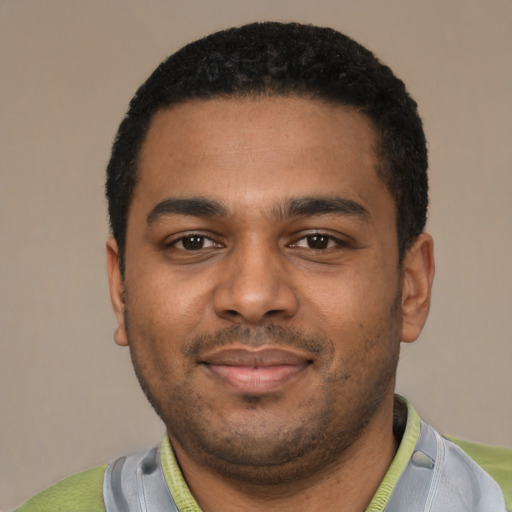 Joyful black young-adult male with short  black hair and brown eyes