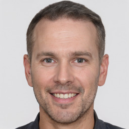 Joyful white adult male with short  brown hair and brown eyes