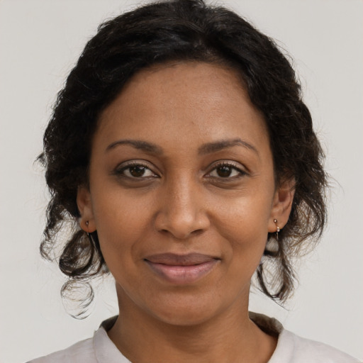 Joyful black adult female with medium  brown hair and brown eyes