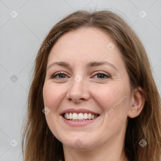 Joyful white young-adult female with long  brown hair and blue eyes