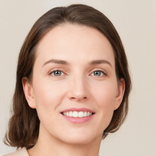 Joyful white young-adult female with medium  brown hair and green eyes