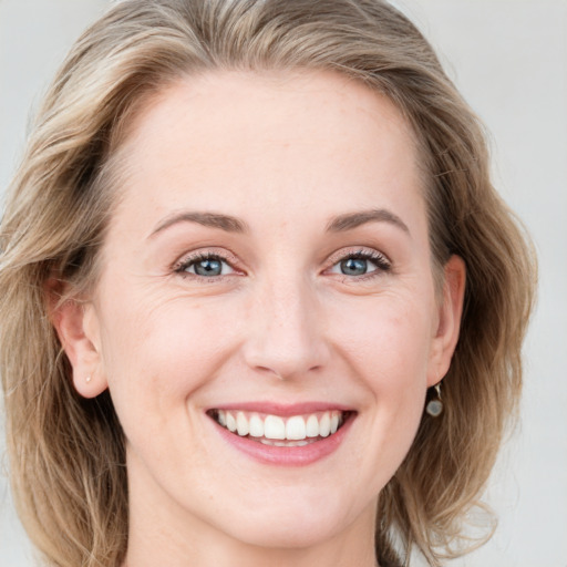 Joyful white young-adult female with medium  brown hair and blue eyes