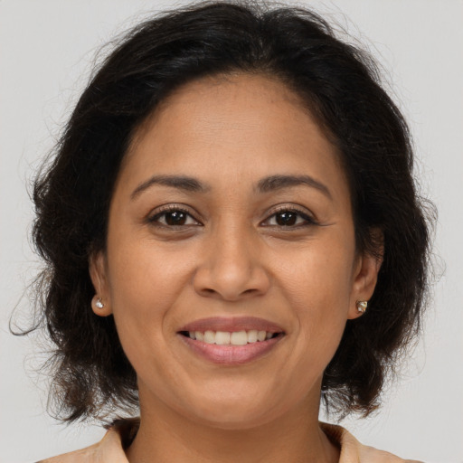 Joyful latino adult female with long  brown hair and brown eyes