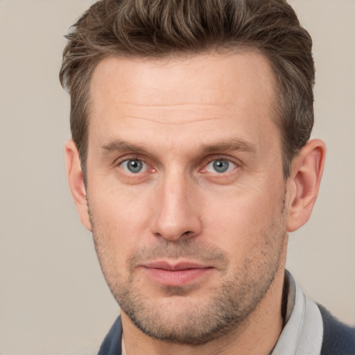 Joyful white adult male with short  brown hair and grey eyes