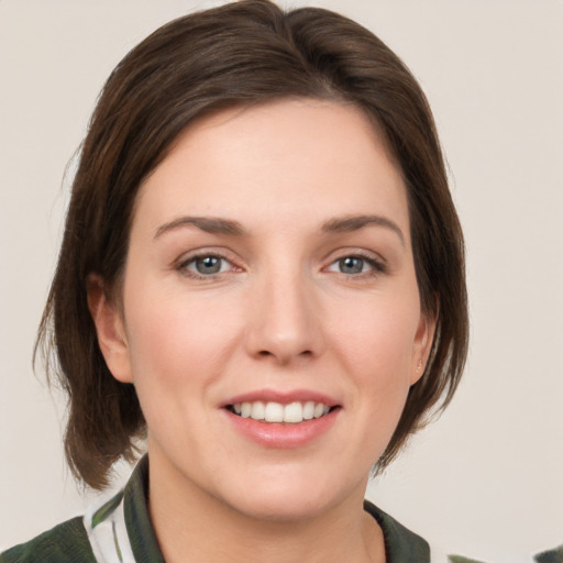 Joyful white young-adult female with medium  brown hair and grey eyes