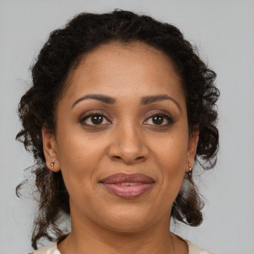 Joyful latino adult female with medium  brown hair and brown eyes