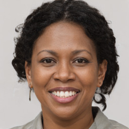 Joyful black adult female with medium  brown hair and brown eyes