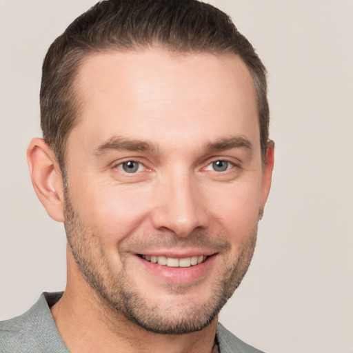 Joyful white young-adult male with short  brown hair and grey eyes