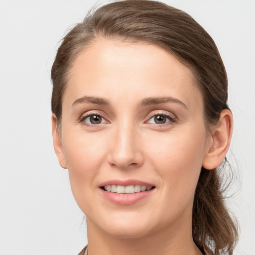 Joyful white young-adult female with medium  brown hair and grey eyes