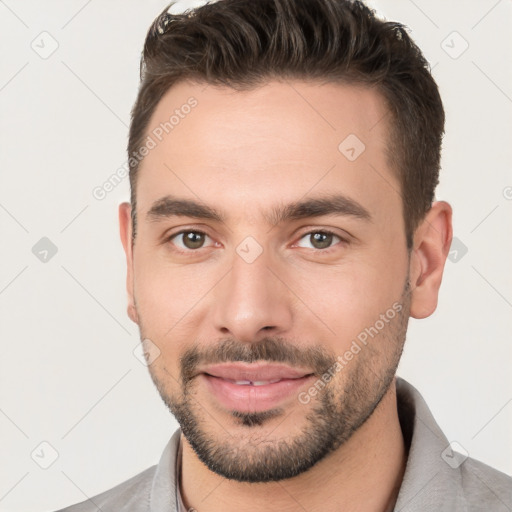 Joyful white young-adult male with short  brown hair and brown eyes