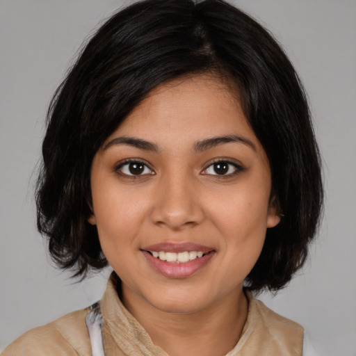 Joyful latino young-adult female with medium  brown hair and brown eyes
