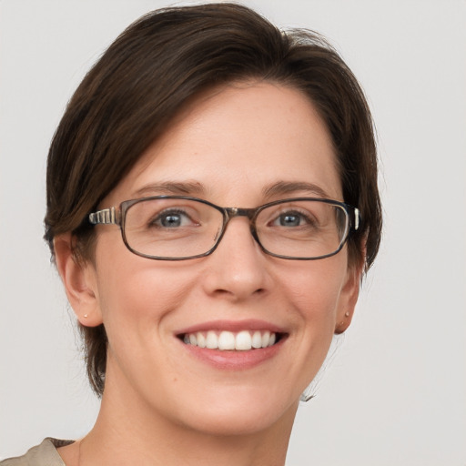 Joyful white young-adult female with short  brown hair and grey eyes