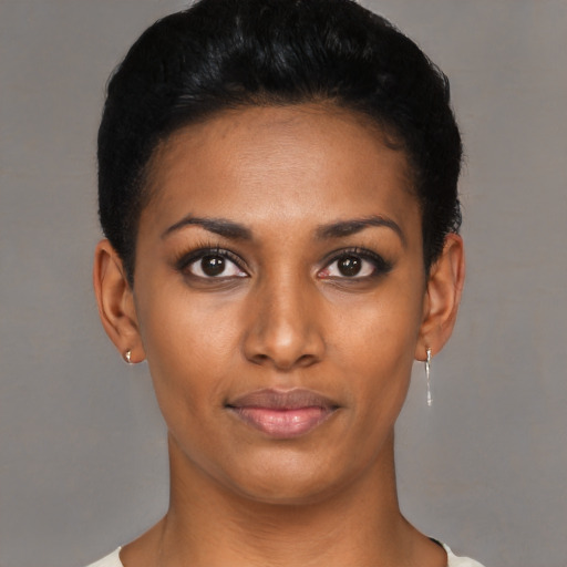 Joyful black young-adult female with short  black hair and brown eyes