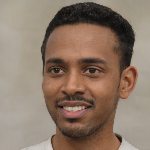 Joyful black young-adult male with short  black hair and brown eyes