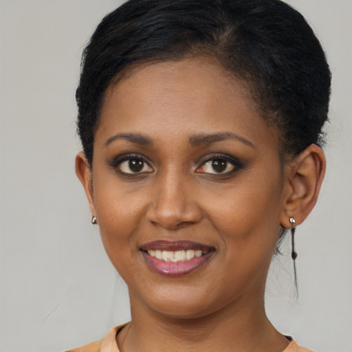Joyful black young-adult female with short  brown hair and brown eyes