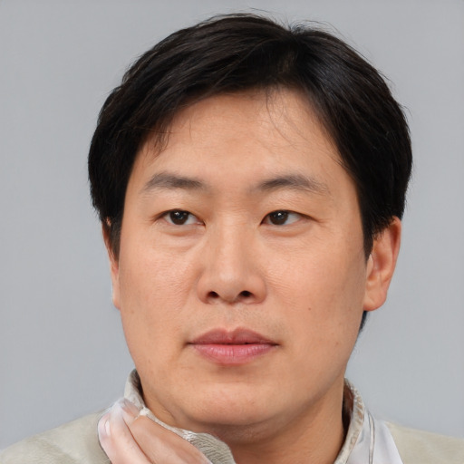 Neutral asian adult male with short  brown hair and brown eyes