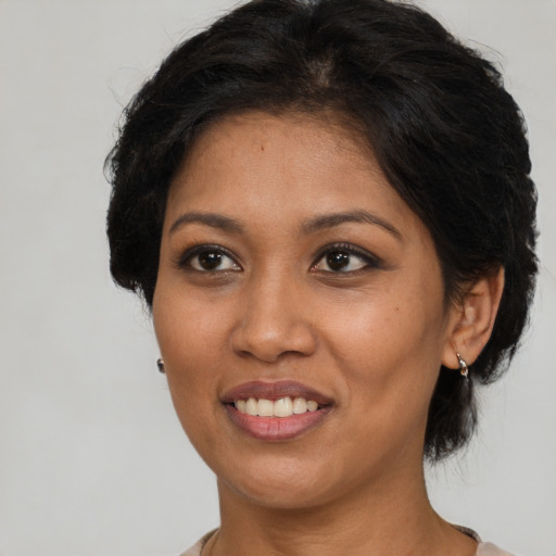 Joyful black adult female with medium  black hair and brown eyes