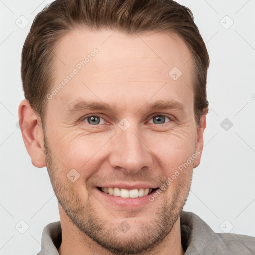 Joyful white young-adult male with short  brown hair and grey eyes