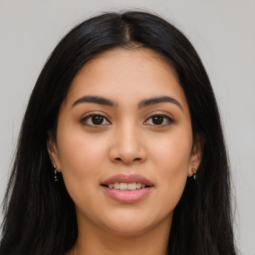 Joyful latino young-adult female with long  black hair and brown eyes