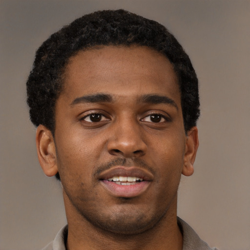 Joyful black young-adult male with short  brown hair and brown eyes
