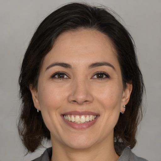 Joyful white adult female with medium  brown hair and brown eyes