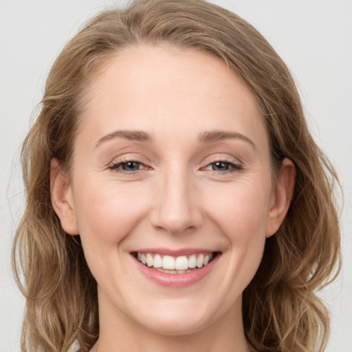 Joyful white young-adult female with long  brown hair and blue eyes