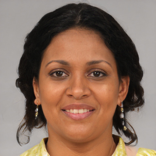 Joyful latino adult female with medium  brown hair and brown eyes