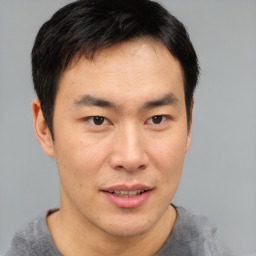 Joyful asian young-adult male with short  brown hair and brown eyes