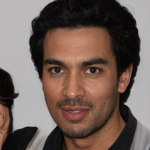 Joyful white young-adult male with short  black hair and brown eyes