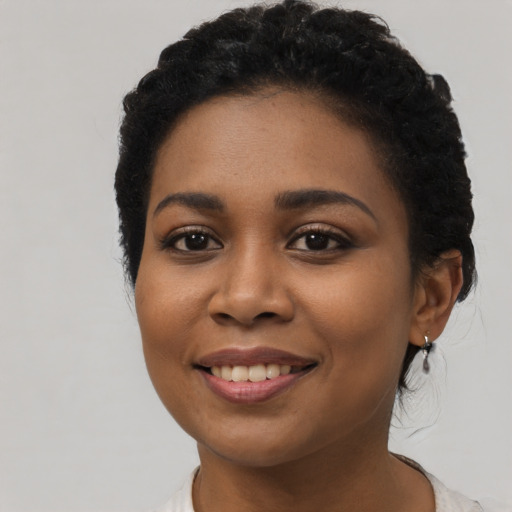 Joyful latino young-adult female with short  black hair and brown eyes