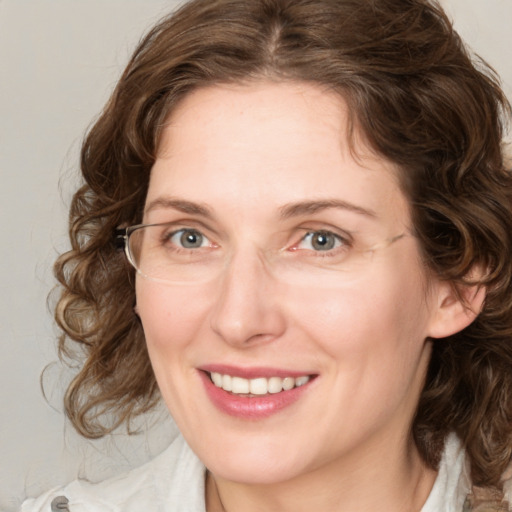 Joyful white adult female with medium  brown hair and blue eyes