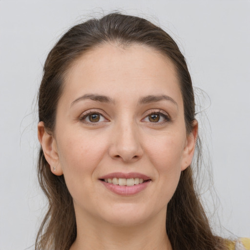 Joyful white young-adult female with long  brown hair and brown eyes