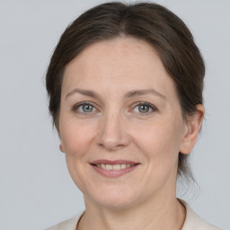 Joyful white adult female with medium  brown hair and grey eyes