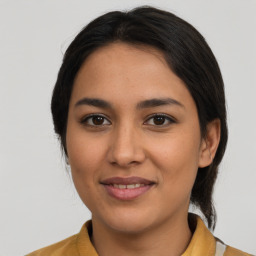 Joyful latino young-adult female with medium  brown hair and brown eyes