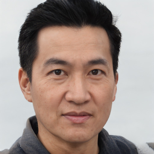 Joyful asian adult male with short  black hair and brown eyes
