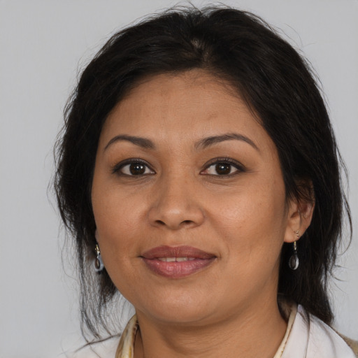 Joyful latino adult female with medium  brown hair and brown eyes