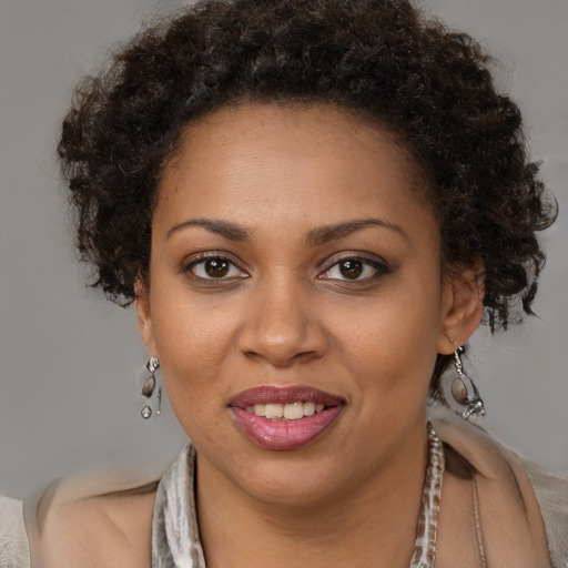 Joyful black young-adult female with short  brown hair and brown eyes