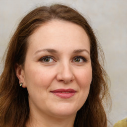 Joyful white adult female with long  brown hair and green eyes