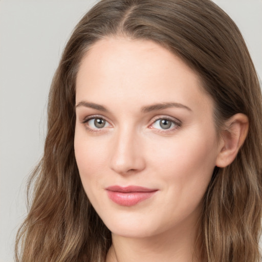 Joyful white young-adult female with long  brown hair and blue eyes